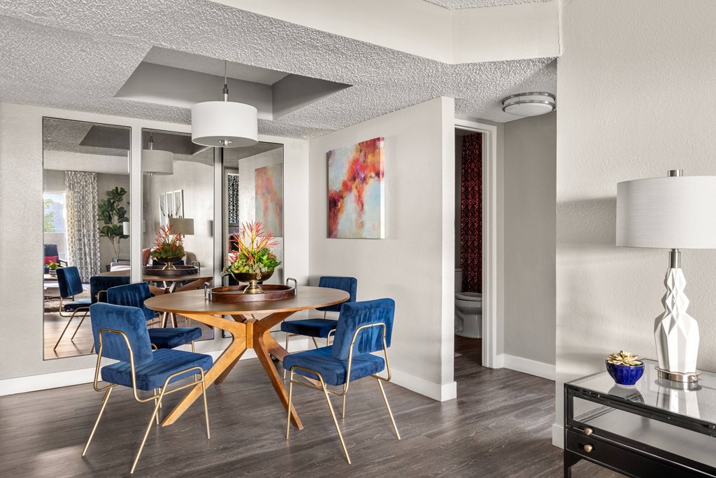 a dining area with a wooden table and blue chairs